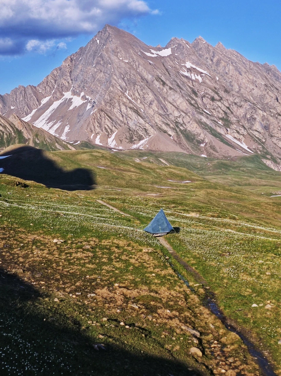 Zelt auf einer Alp des TMB Anfang Juni, winzig unter dem Gipfel und dem noch vorhandenen Schnee: eine Stimmung, die es so nicht mehr gibt, sobald die Hochsaison läuft